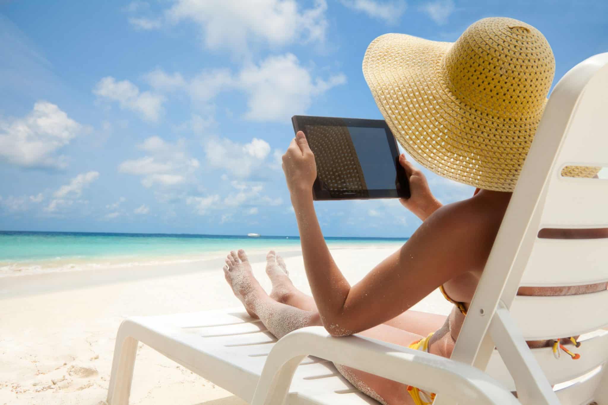 Отдыхать в течении дня. Девушка с ноутбуком на берегу моря. Отдых на пляже. Отдыхать на море. Шезлонг на пляже.